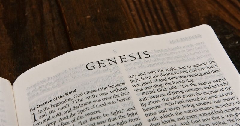 An open Bible showing the first page of the Book of Genesis